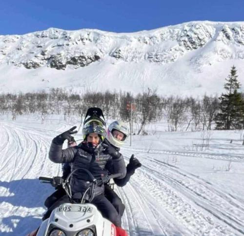 two people riding on a snowmobile in the snow at Kultsjögården-Saxnäs- Marsfjäll 10 in Saxnäs