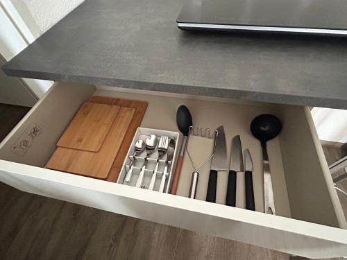 a drawer under a kitchen counter filled with utensils at SkyApartment#101 in Frankfurt
