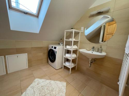een badkamer met een wasmachine en een wastafel bij Taverna Apartman in Monor