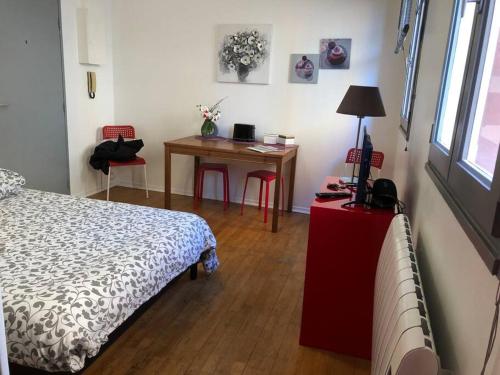 - une chambre avec un lit et un bureau avec une table dans l'établissement Saint-Sernin - Centre-ville - Calme - WIFI fibre, à Toulouse