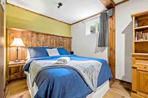- une chambre avec un lit bleu et un mur jaune dans l'établissement Tremblant-Mont-Blanc SPA,Nature,Intimité, à Saint-Faustin–Lac-Carré