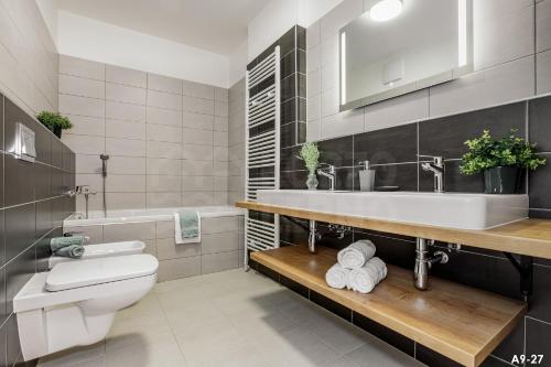 a bathroom with a toilet and a sink and a tub at KORZO LIPNO 2 in Lipno nad Vltavou