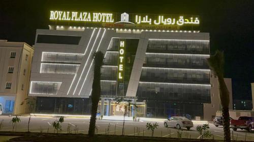 a building with a sign on top of it at night at Royal Plaza Hotel in Duqm