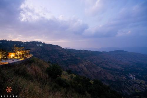 a house on top of a hill with a view at Zostel Plus Panchgani in Panchgani