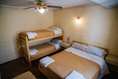Habitación pequeña con 2 camas y ventilador de techo. en Hotel Panamericano en 