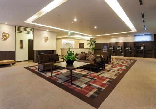 a lobby with a waiting room with a couch and a table at Daiwa Roynet Hotel Oita in Oita