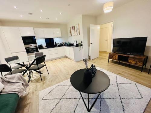 ein Wohnzimmer mit einem Couchtisch und einer Küche in der Unterkunft High-Spec Skyline Apartment in London - 2 BDR & Balcony in London