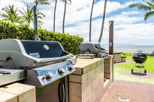 a grill and bbq equipment on a patio overlooking the ocean at Molokai Shores in Kaunakakai