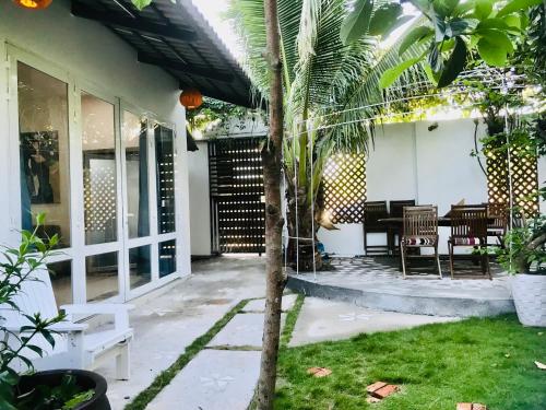 a house with a palm tree in the yard at Casa Vi Mia in Ấp Thiện Sơn