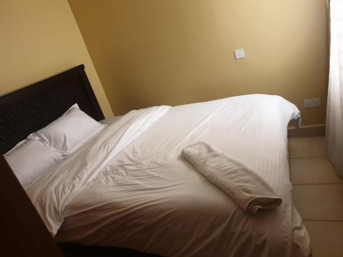 - un lit blanc avec un oreiller dans l'établissement Solomon's Palace - Nairobi, à Nairobi