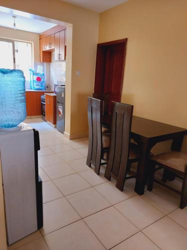 a kitchen and dining room with a table and chairs at Solomon's Palace - Nairobi in Nairobi