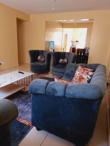 a living room with a blue couch and two couches at Solomon's Palace - Nairobi in Nairobi