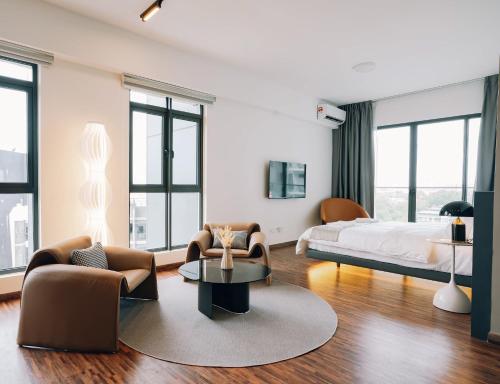 a bedroom with a bed and two chairs and a table at K AVENUE TOWER B by The Pillow House, 5 Minutes to KKIA Airport in Penampang