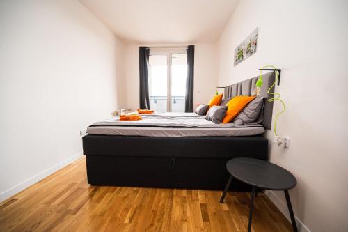 um quarto com uma cama grande e almofadas laranja em Sarajevo Tower 24th floor apartment em Sarajevo