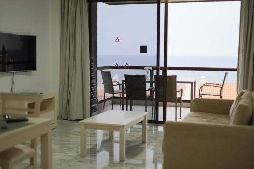 聖地亞哥港的住宿－Bahia de Santiago，客厅配有沙发和桌子