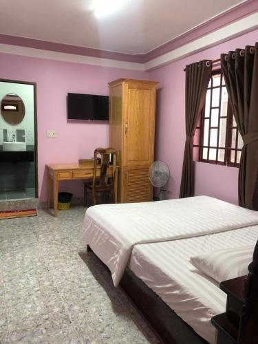 a bedroom with a bed and a desk at Nhat Quynh Hotel in Da Lat