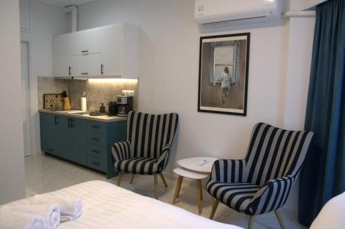 1 dormitorio con 2 sillas, mesa y cocina en Rooster Ioannina, en Ioannina