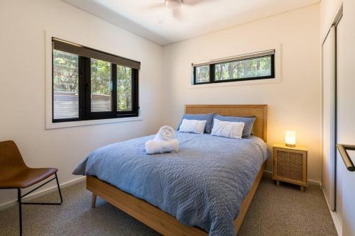 a bedroom with a bed with a pillow on it at Flame Tree Retreat in Margaret River Town