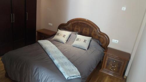 a bed with a wooden headboard and two pillows at Family Home Downtown with Balcony, Casablanca in Casablanca