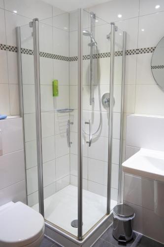 a shower with a glass door in a bathroom at Hotel Am Freischütz in Hürth
