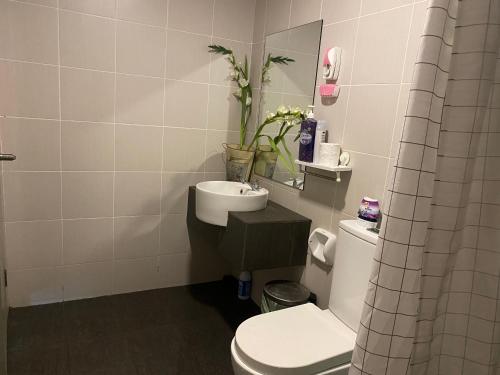 La salle de bains est pourvue de toilettes blanches et d'un lavabo. dans l'établissement Bangi Evo Mall by Maya Spa with Wifi & Great View, à Bandar Baru Bangi
