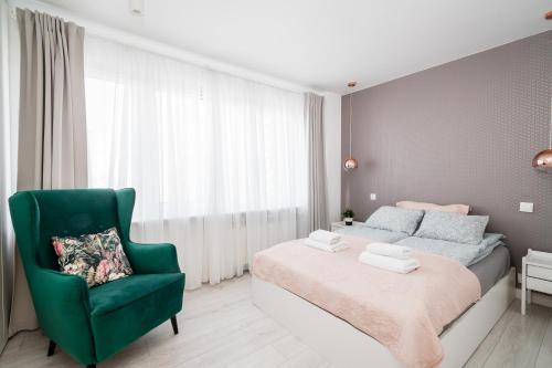 克拉科夫的住宿－Cracow View Residence WAWELOFTS，一间卧室配有一张床和一把绿色椅子