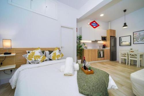 Cet appartement comprend une chambre avec un grand lit blanc et une cuisine. dans l'établissement (J1) Ubicado en Madrid Centro - 5 personas., à Madrid