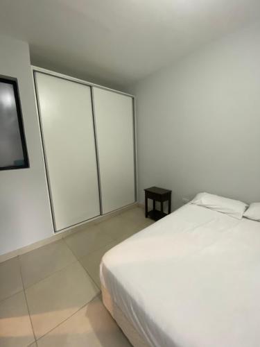 a white bedroom with a bed and a window at LITZ in Concepción