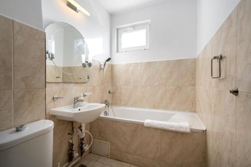 a bathroom with a sink and a bath tub at Studio 37 by MRG Apartments in Bucharest