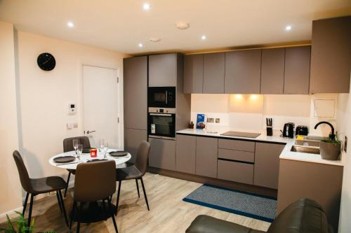 cocina y comedor con mesa y sillas en City Centre Luxury Apartment, en Belfast