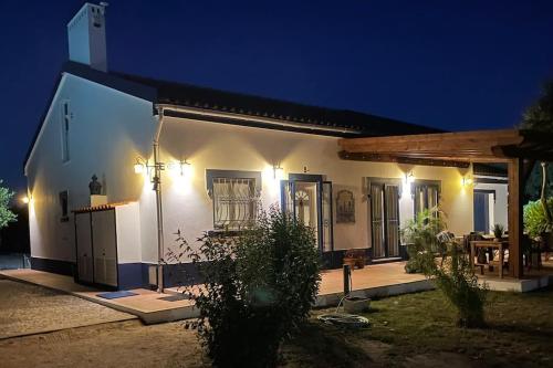 Monte Velho - Country House في Canha: منزل أبيض صغير في الليل مع أضواء