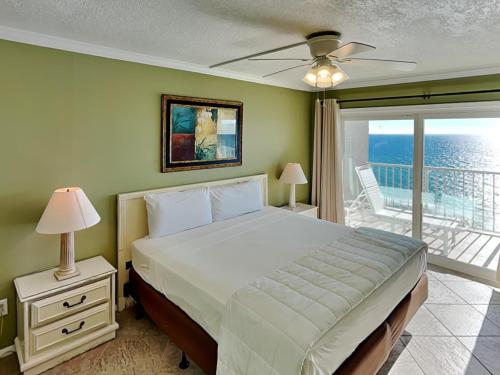 um quarto com uma cama e uma varanda com o oceano em Summit Beach Resort 1508 em Panama City Beach