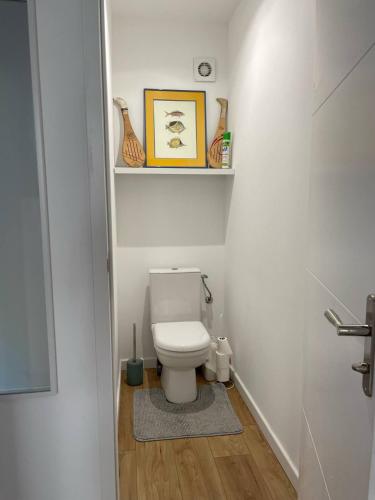 La salle de bains est pourvue de toilettes et d'une étagère avec des vases. dans l'établissement Maison avec jardin proche Lac - Quartier calme, à Carcans