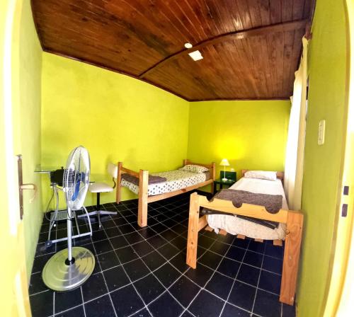 a small room with two beds and a fan at Hostal - Sueños del Rio in Concepción del Uruguay