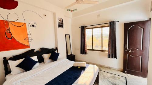 1 dormitorio con 1 cama con una pintura en la pared en Omkar Palace, en Udaipur