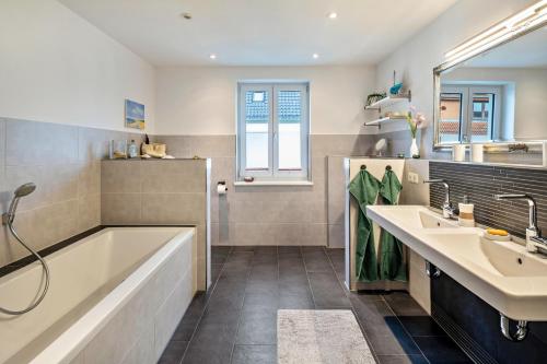 a bathroom with a tub and two sinks at Apartement Hangarstein in Kassel