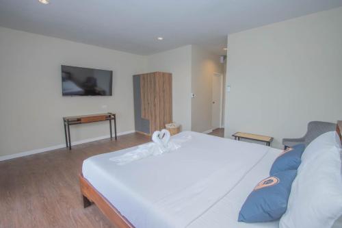 a bedroom with a large white bed with blue pillows at RoomQuest The Peak Patong Hill in Patong Beach
