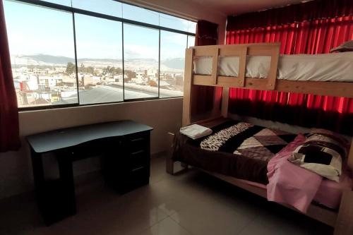 万卡约Depawanka 2的一间卧室，里面有一张床、一张桌子和一扇窗户。