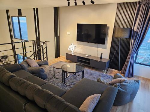 a living room with a couch and a flat screen tv at Arte Cheras The Premium Suites by iLuxHome in Kuala Lumpur