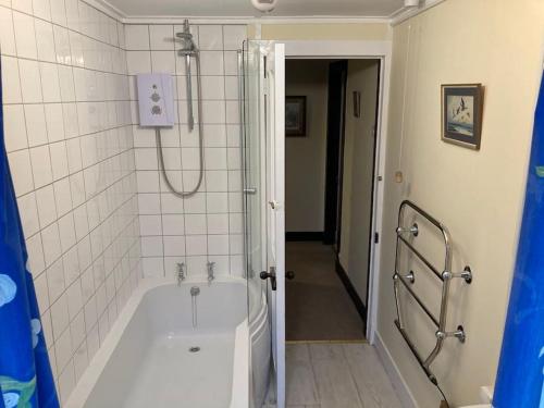 a bathroom with a bath tub and a shower at Ardnadrochet Cottage in Lochdon