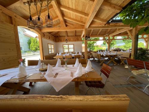 een restaurant met houten tafels met witte servetten erop bij Gasthof Hummel Hotel 