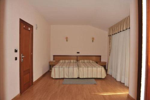 a bedroom with a bed and a wooden floor at Hotel Alfar in Isla