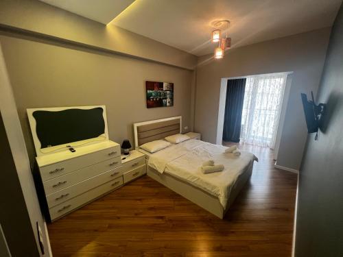 ein Schlafzimmer mit einem Bett, einer Kommode und einem TV in der Unterkunft Park Azure 11523 in Baku