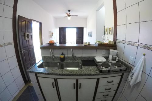 a small kitchen with a sink and a stove at Casa Flora in Cabo Frio
