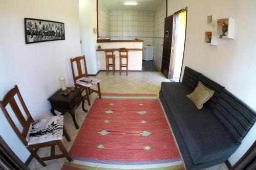 a living room with a couch and chairs and a kitchen at Casa Flora in Cabo Frio