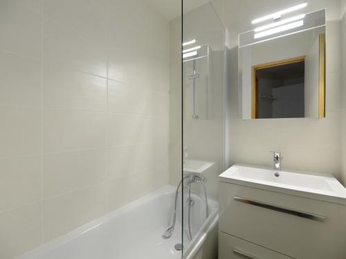 une salle de bain blanche avec un lavabo et une douche dans l'établissement Appartement confortable au pied des pistes avec balcon | 5 pers - FR-1-181-2031, à La Plagne Tarentaise