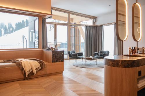 Schlafzimmer mit einem Bett, einem Schreibtisch und Stühlen in der Unterkunft Hotel Nesslerhof in Großarl