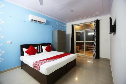 um quarto com uma cama grande e almofadas vermelhas em OYO Flagship 44151 Royal Guest House em Garhi Harsāru