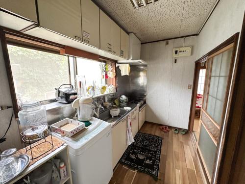 a small kitchen with a sink and a dishwasher at 八戸ゲストハウス トセノイエ / Hachinohe Guest House Tosenoie in Hachinohe