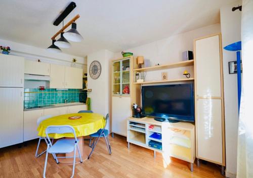 - une cuisine avec une table et une télévision dans la chambre dans l'établissement Appartement familial T2 La Mongie, 6personnes,calme et agréable, à Bagnères-de-Bigorre